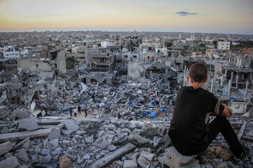 202472_a_palestinian_child_sits_above_the_ruins_of_his_ruined_home_1.jpg