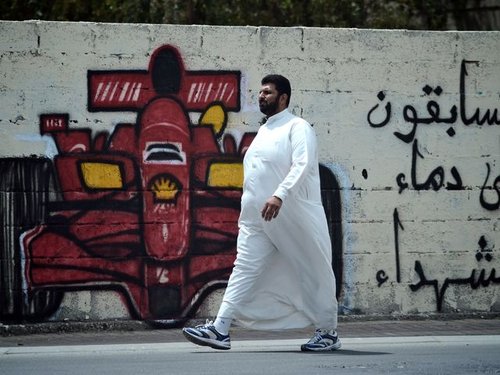 209610_a_bahraini_shiite_man_walks_past_graffit_0.jpg