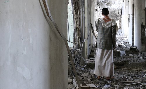 A man stands in rubble of destroyed building in Sa'ada.
