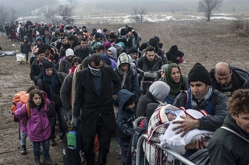 Migrants and refugees wait for security check after crossing the Macedonian border into Serbia