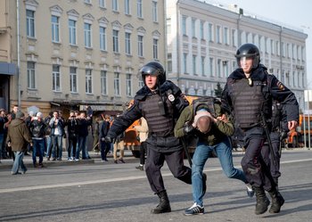 Riot police officers detain a protester during an unauthorised anti-corruption rally in central Moscow.
