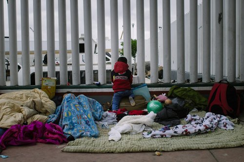 Billboard and migrant caravan in Tijuana