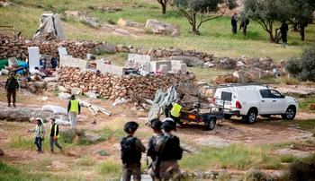 Israeli soldiers stand guard as Israeli workers remove a tent that was pitched near the Israeli settlement of Susya on March 28, 2018 after its resident Palestinian family was warned to evacuate.