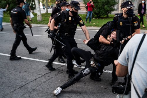Police arresting a protester in Madrid, Spain, after violent clashes during a protest against the new measures to stop the spread of coronavirus.