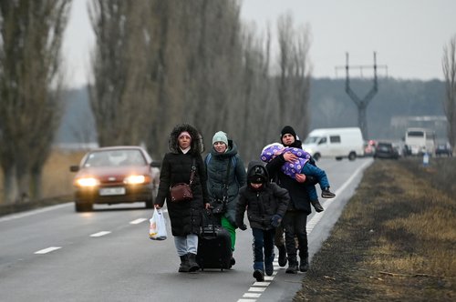 Refugees from Ukraine walk a road after crossing the Moldova-Ukrainian border's checkpoint near the town of Palanca on March 1, 2022