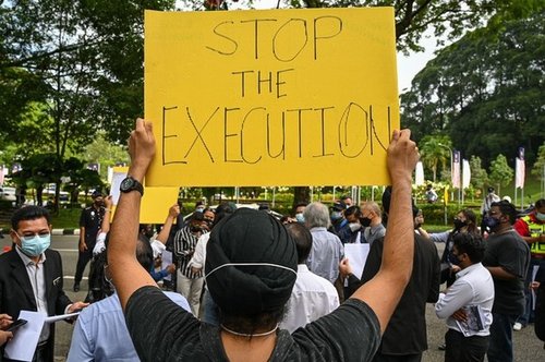 An activist holds a placard before submitting a memorandum to parliament in protest at the impending execution of Nagaenthran K. Dharmalingam