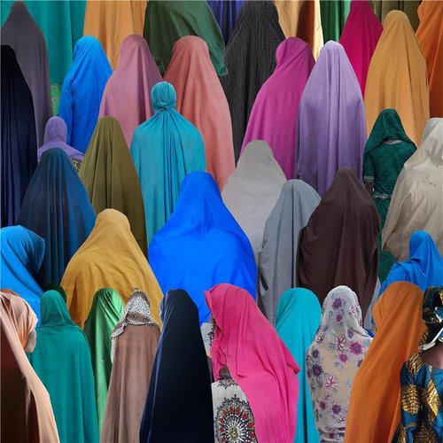 Women are seen from behind wearing traditional, loose Islamic dress in a variety of colours