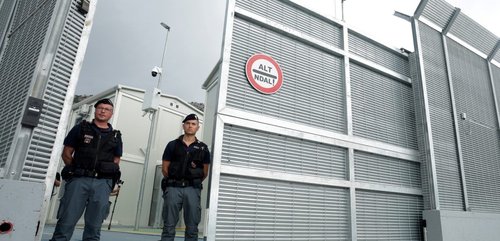 enforcement officers stand in front of a detention centre