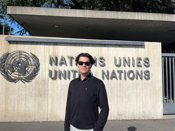 Enes Hocaoğulları standing in front of a UN sign