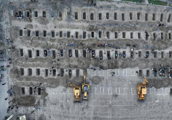 In this aerial handout picture released by the Iranian Press Center, mourners dig graves during the funeral for children killed in a reported strike on a primary school in Iran's Hormozgan province in Minab on March 3, 2026.