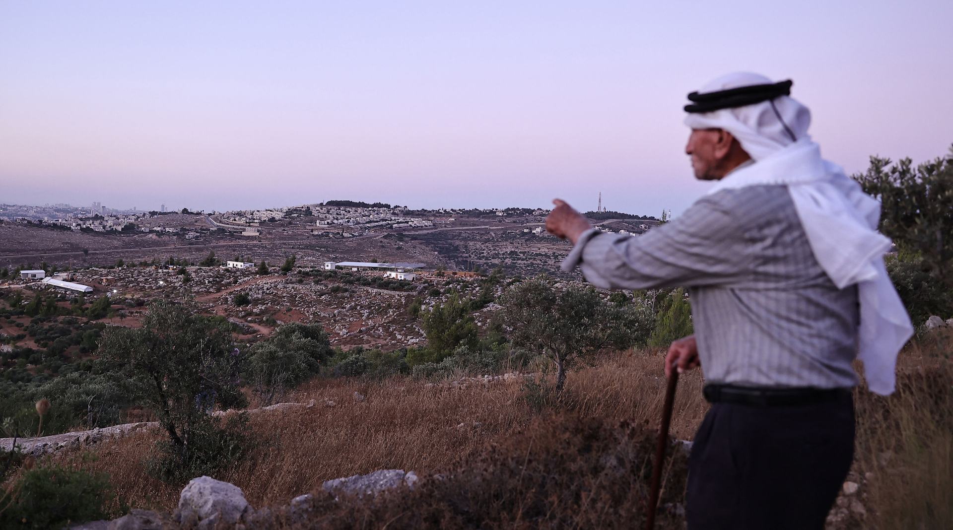 Olayan Olayan, who was born in the village of Battir in 1941, overlooks a valley in which a new Israeli settlers outpost is built, as pictured from Battir, a UNESCO heritage village in the occupied West Bank