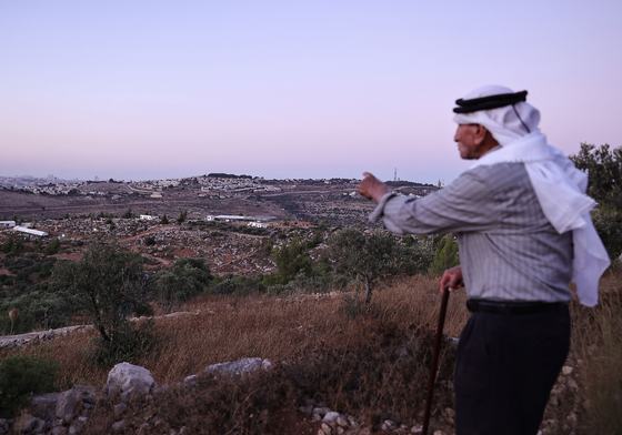 Olayan Olayan, who was born in the village of Battir in 1941, overlooks a valley in which a new Israeli settlers outpost is built, as pictured from Battir, a UNESCO heritage village in the occupied West Bank
