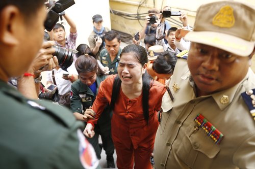 Image shows Tep Vanny approaching the court, accompanied by a uniformed guard