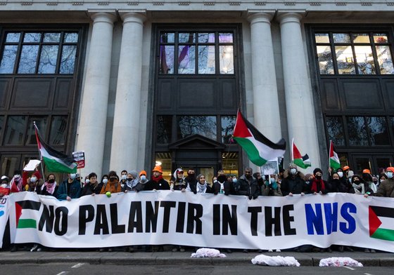 People holding a banner that reads No Palantir in the NHS