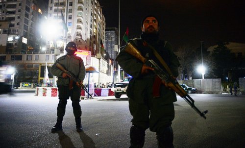 Afghan policemen stand guard in front of the Serena Hotel in Kabul on March 21