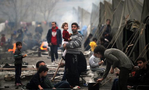 A Syrian refugee holds a baby in Harmanli refugee camp, Bulgaria