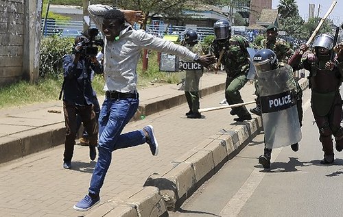 A protestor runs from anti-riot police on 26 September 2017 in Nairobi, during a demonstration to demand the removal of officials from national election oversight body
