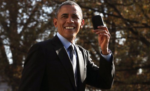 President Barack Obama holds up his Blackberry