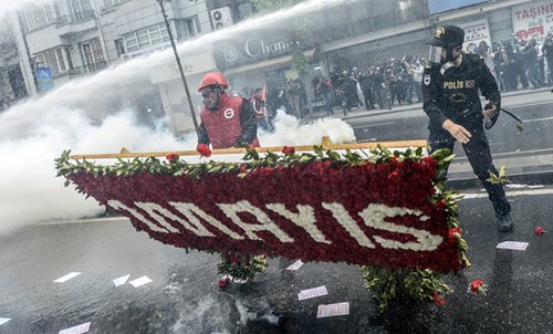 A Turkish protester is fired at with a water cannon near Taksim Square