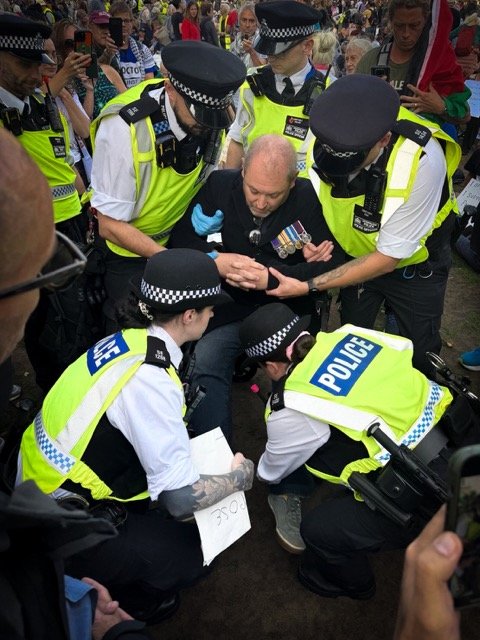 Elderly man at Defend Our Juries protest getting arrested by multiple police officers