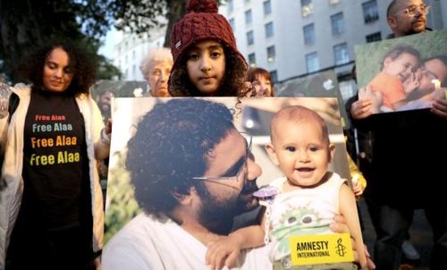 Child holding photo of Alaa Abdel Fattah