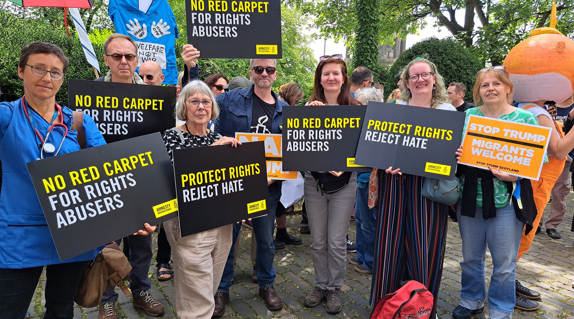 Amnesty Scotland activists holding placards at a protest