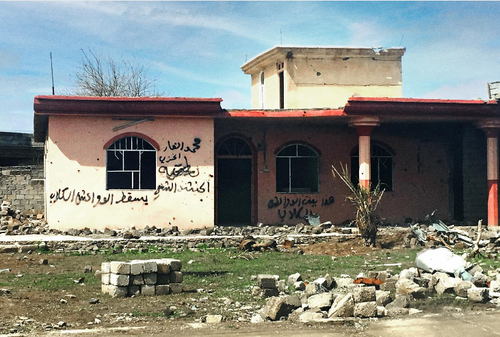 A house daubed with the words 'This is the home of Daesh dogs' in the town of Hammam al-Alil in Ninewa governorate