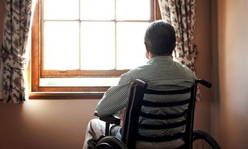 Elderly man looking out window
