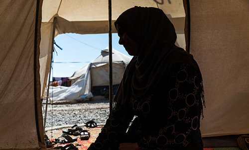 Silhouette of woman in displacement camp in Iraq for perceived ties to Islamic State