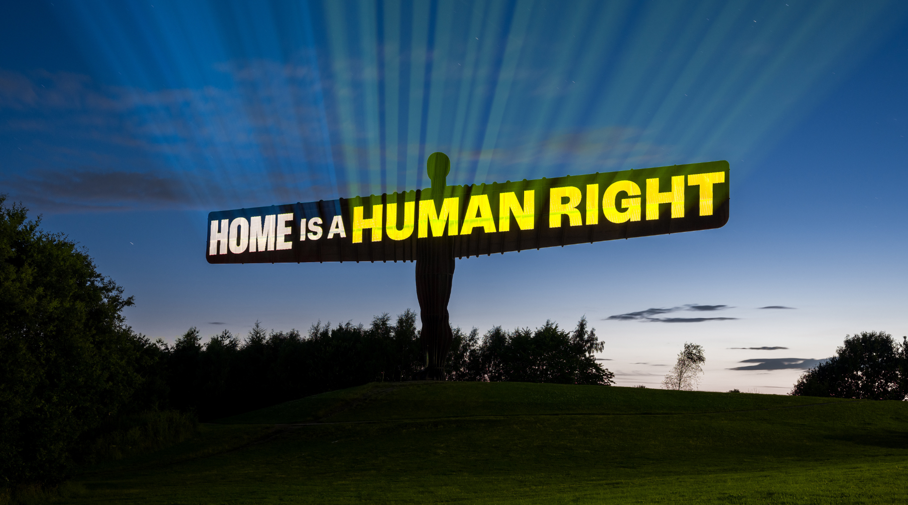 Angel of the North with 'Home is a human right' projected on to it