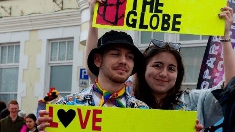 Two people holding love is a human right banners