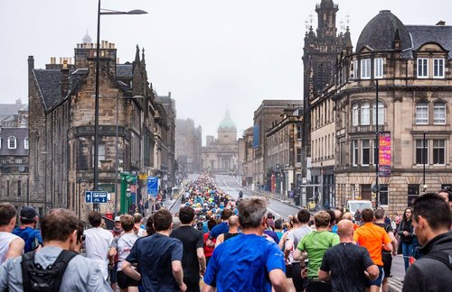 Hundreds of people run alongside a beautiful Edinburgh street