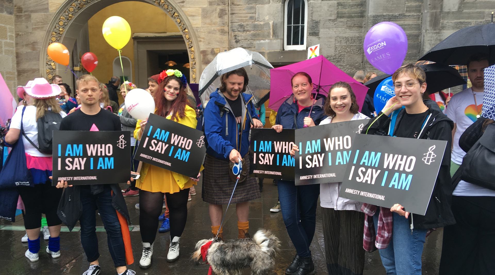 Amnesty Volunteers marching at Edinburgh Pride with trans rights placards saying 'I Am Who I Say I Am'