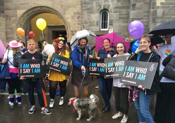 Amnesty Volunteers marching at Edinburgh Pride with trans rights placards saying 'I Am Who I Say I Am'