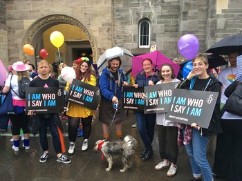 Amnesty Volunteers marching at Edinburgh Pride with trans rights placards saying 'I Am Who I Say I Am'
