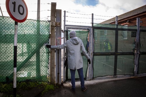 A young male asylum seeker using the only entrance to get inside Napier Barracks, 12 January 2021, Folkestone, United Kingdom. Over 400 asylum seekers are being kept at Napier Barracks in unsuitable.