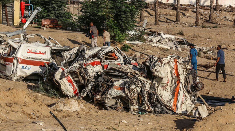 A Palestinian woman stands among complete devastation of street with buildings turned to rubble by Israeli bombing.