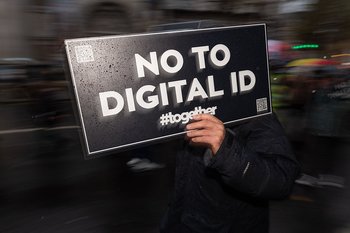 A demonstrator holds a placard reading "No to Digital ID...