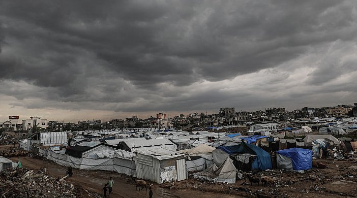Hundreds of tents in Gaza underneath storm clouds.