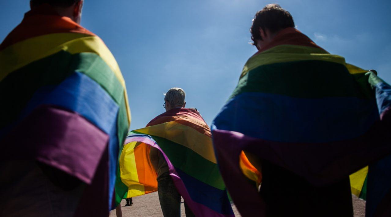 LGBT+ flag draped on people