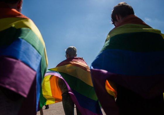 LGBT+ flag draped on people