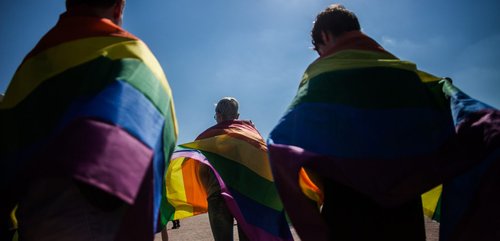 LGBT+ flag draped on people