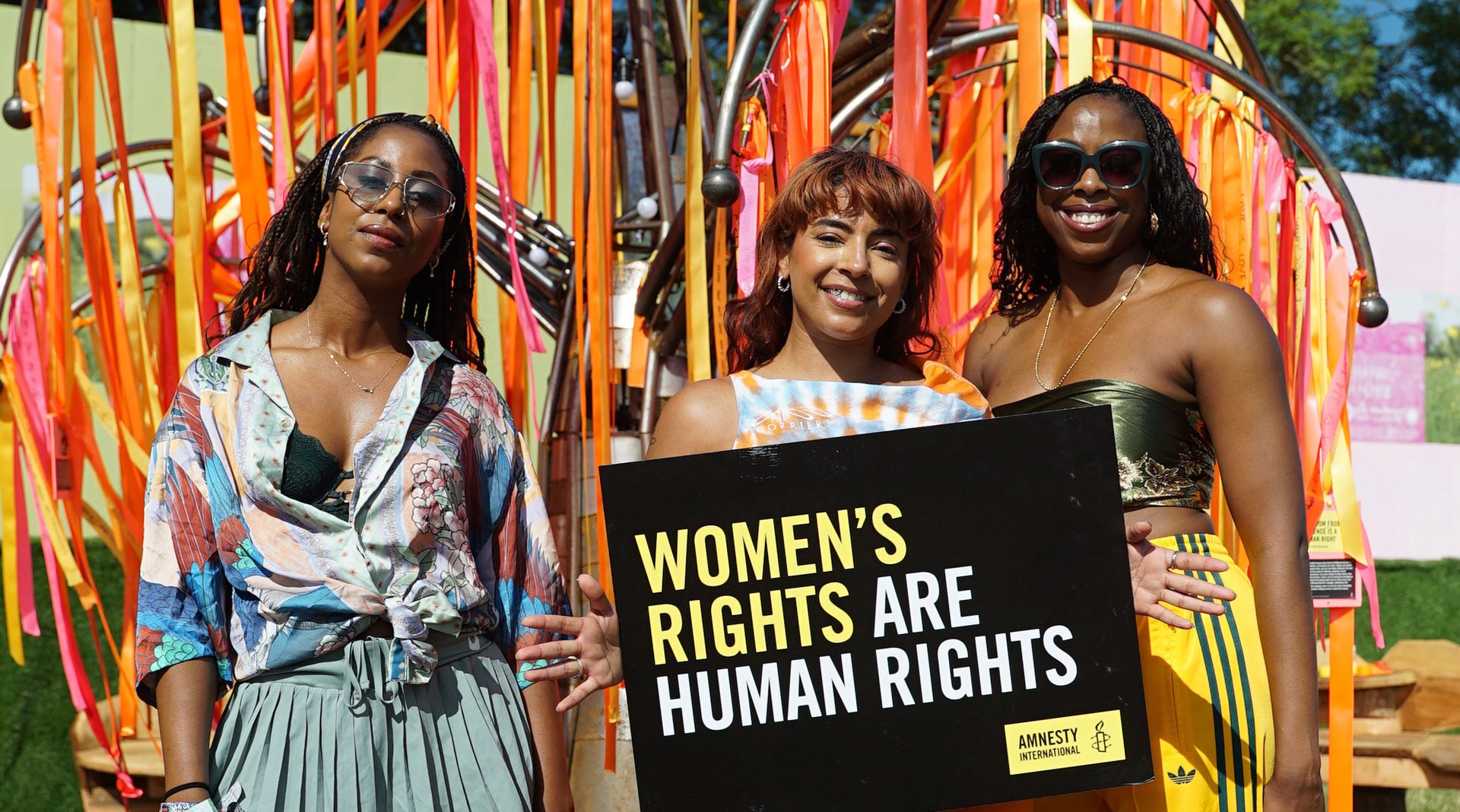 Women holding an Amnesty placard that reads Women's Rights Are Human Rights