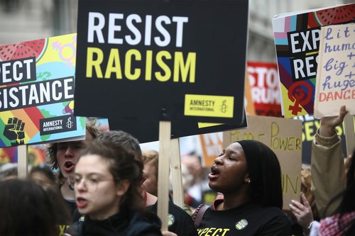 Activists holding a banner reading 'resist racism'