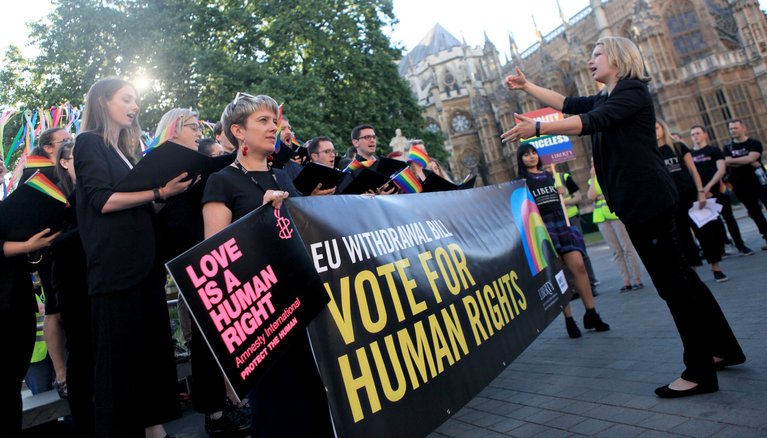 Amnesty activist holding a banner that reads Vite For Human Rights