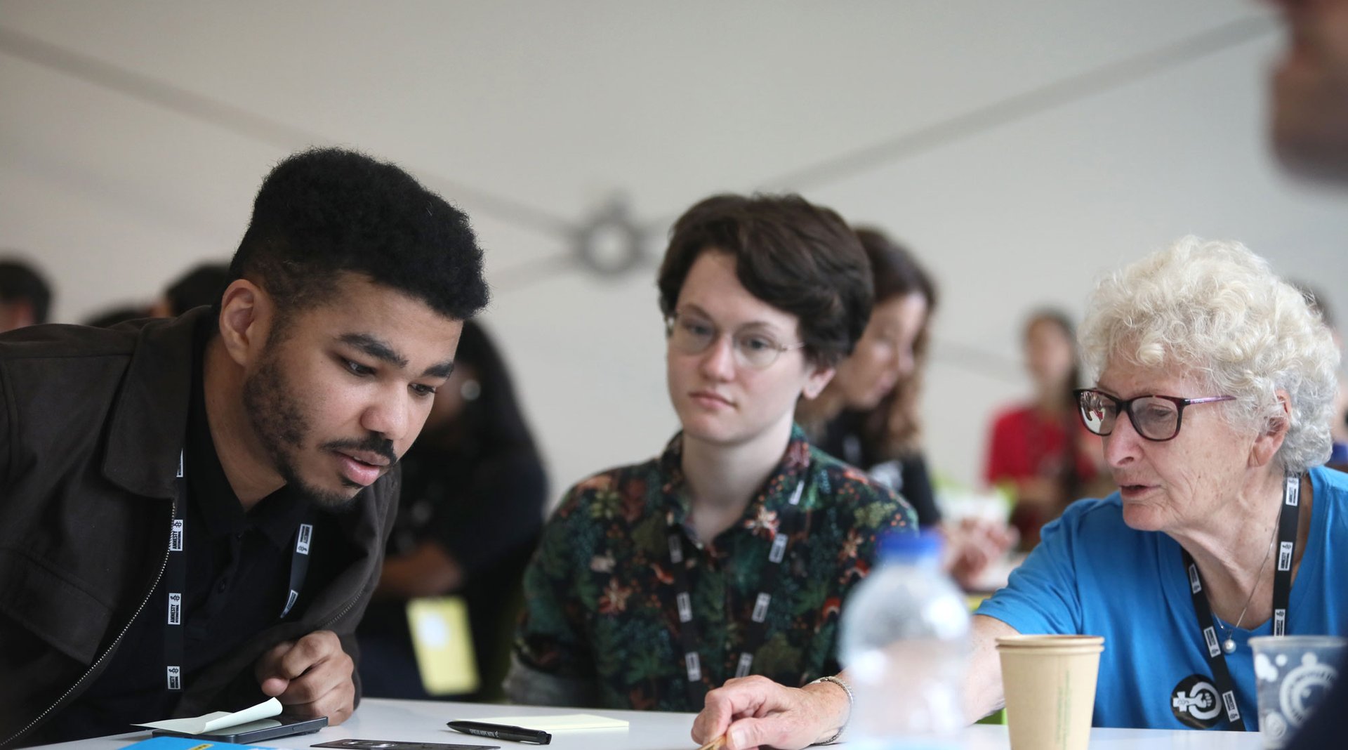 Amnesty activists sitting at a table at Amnesty amplify and collaborating on a task