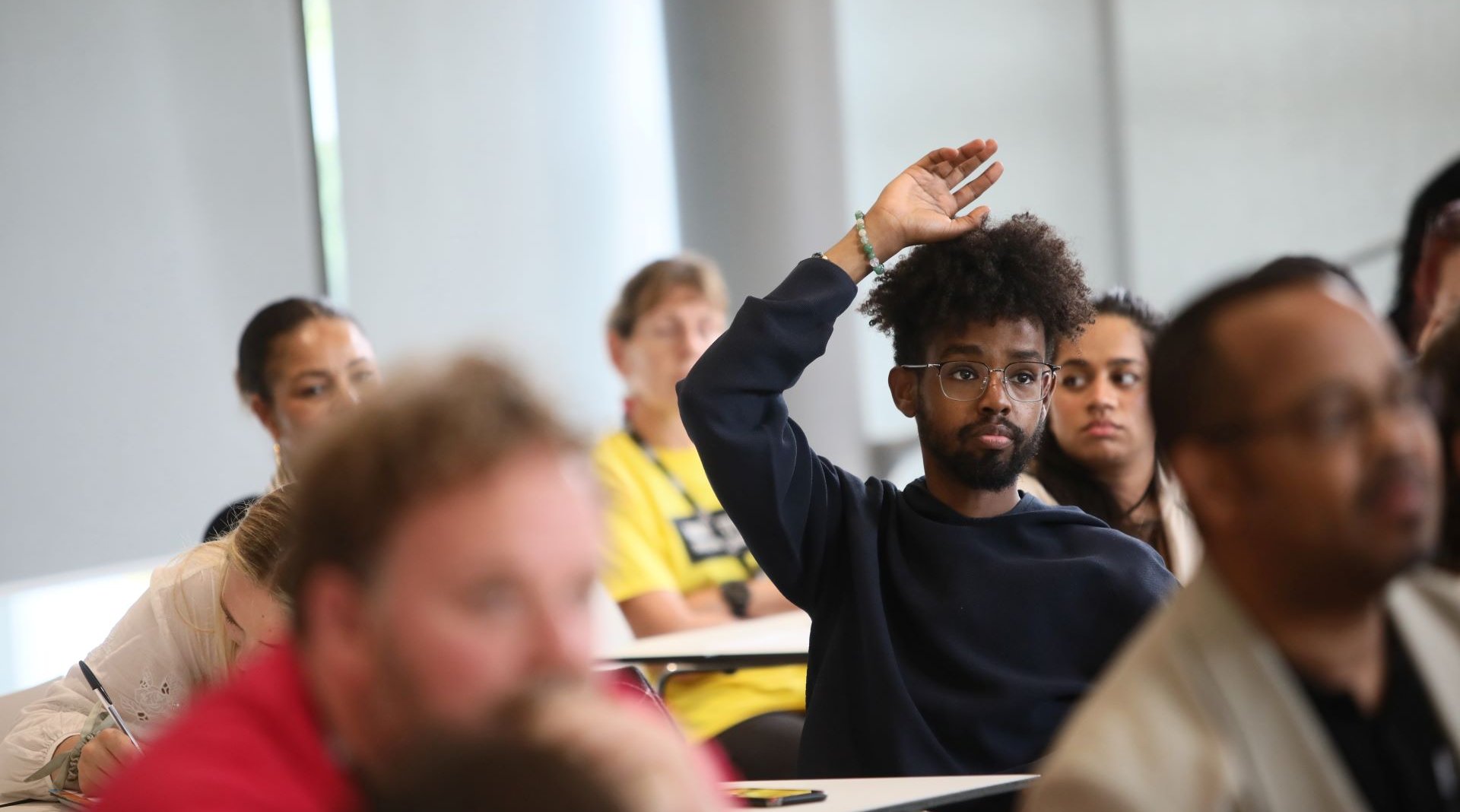 Individual raising hand at a conference.