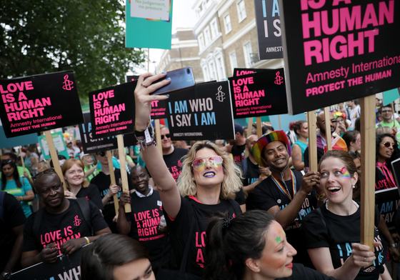 Amnesty protest where people are holding up Love Is A Human Right placards.