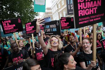Amnesty protest where people are holding up Love Is A Human Right placards.