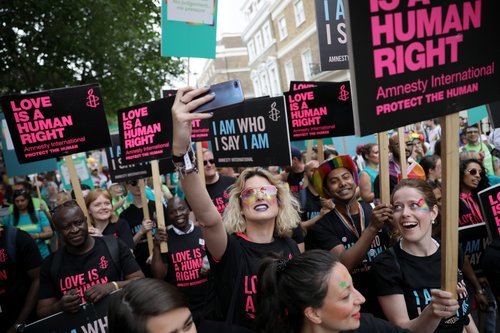 Amnesty protest where people are holding up Love Is A Human Right placards.